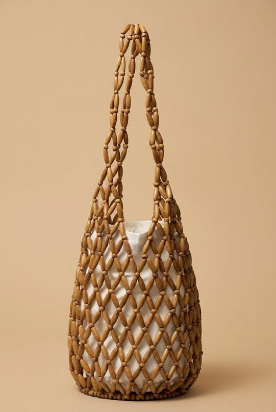 Close-up of the Perla beaded bucket bag showing the hand-beaded surface and rounded shape
